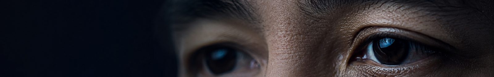 Ultra-macro close-up of a thoughtful gaze, eyes set against a dark backdrop.